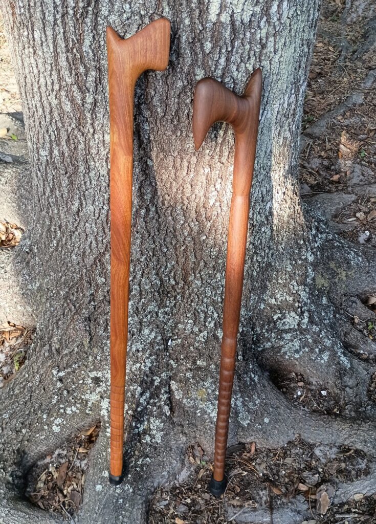 Two solid wood, single piece self-defense canes. The lighter colored one is cumaru and the darker one is ipe. Crafted 05-28-2025 Sarasota, FL